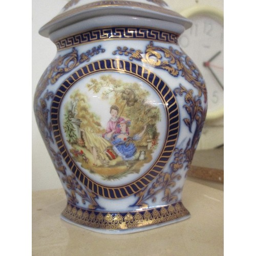 60 - PAIR OF DECORATIVE PORCELAIN LIDDED VASES WITH PANELS IN BLUE AND GILT WITH PASTORAL PANELS - 24CM