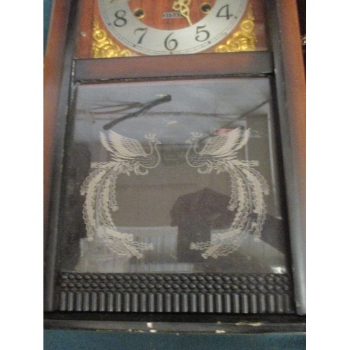 202 - 2 LONG CASE WALL CLOCKS. 1 OF WHICH IS MORE DECORATIVE WITH PEACOCKS ETCHED INTO THE GLASS.