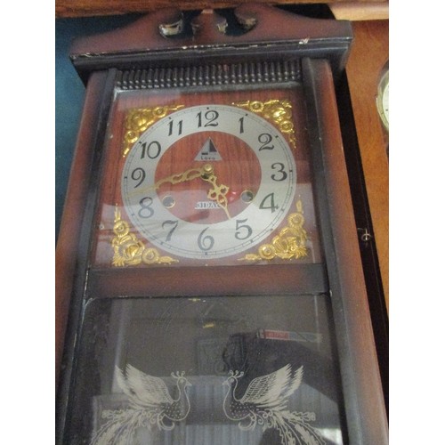 202 - 2 LONG CASE WALL CLOCKS. 1 OF WHICH IS MORE DECORATIVE WITH PEACOCKS ETCHED INTO THE GLASS.