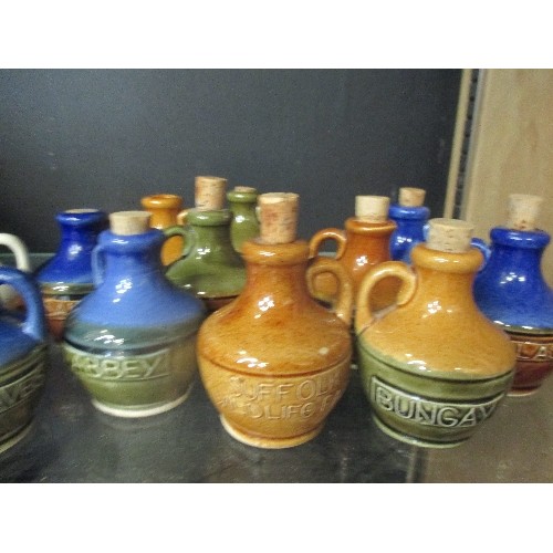 242 - COLLECTION OF MINIATURE GLAZED STONEWARE DECANTERS WITH CORK STOPPERS. EACH HAS A DIFFERENT NAME IE ... 