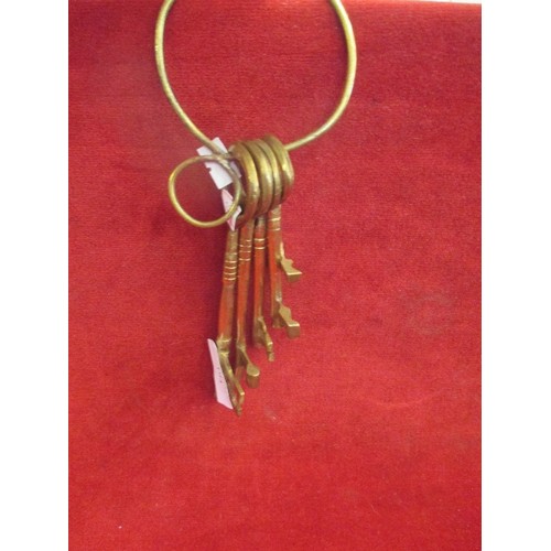 194 - ORNAMENTAL BRASS KEYS ON A LARGE KEYRING