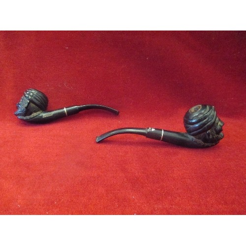 100 - TWO UNUSUAL EARLY 20TH CENTURY GUTTA PERCHA  PIPES, THE BOWLS CARVED WITH A MAN'S HEAD IN A TURBAN. ... 