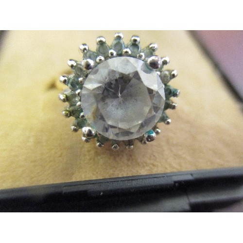 22 - A RING WITH A LARGE WHITE STONE AND A CLUSTER OF LIGHT BLUE STONES SIZE O