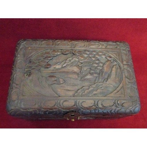 74 - HIGHLY CARVED ORIENTAL HINGED WOODEN BOX. CONTAINS HESSIAN BAG WITH TERRACOTTA AND ALSO WOODEN SYMBO... 