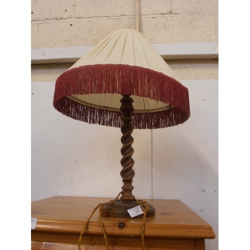 139 - AN OAK TABLE LAMP WITH BARLEY TWIST COLUMN - IVORY PLEATED SHADE WITH RED FRINGE