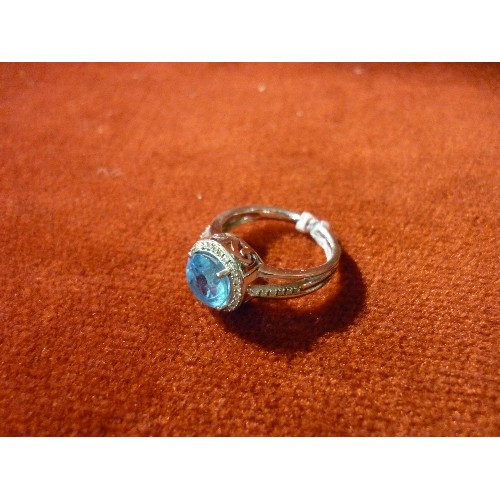 34 - WHITE GOLD BIRMINGHAM HALLMARKED RING SET WITH LARGE PALE BLUE STONE SURROUNDED BY 