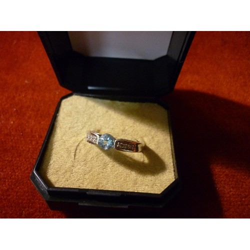 38 - A 9CT WHITE GOLD RING SET WITH A PALE BLUE STONE. THE SHOULDERS SET WITH CLEAR STONES - SIZE N/O