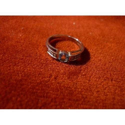 38 - A 9CT WHITE GOLD RING SET WITH A PALE BLUE STONE. THE SHOULDERS SET WITH CLEAR STONES - SIZE N/O