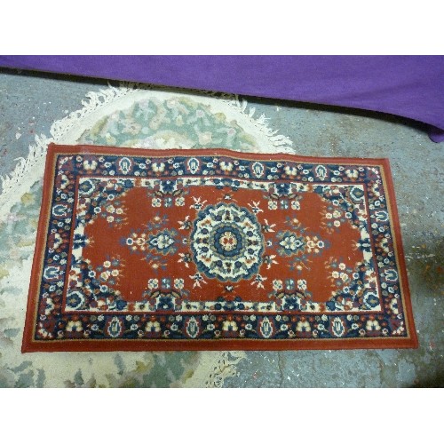 163 - 2 RUGS. A DEEP RED/NAVY/GREEN/CREAM RECTANGULAR 60 X 110CM. AND A PASTEL OVAL RUG WITH FRINGE.