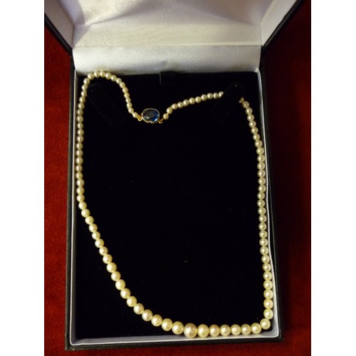 64 - AN ELEGANT GRADUATED PEARL NECKLACE, THE GOLD (UNTESTED) CLASP SET WITH A CUSHION CUT SAPPHIRE - 40C... 