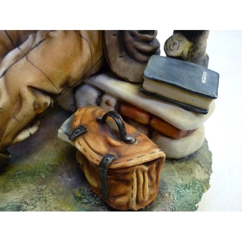 223 - A LARGE CAPODIMONTE FIGURE OF AN OLD GENTLEMAN READING ON A BENCH - SIGNED ON THE BACK 