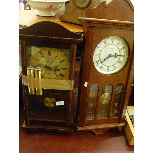 229 - 2 WALL CLOCKS WITH PENDULUMS. IN GLASS/WOOD CASES. ROMAN NUMERALS.