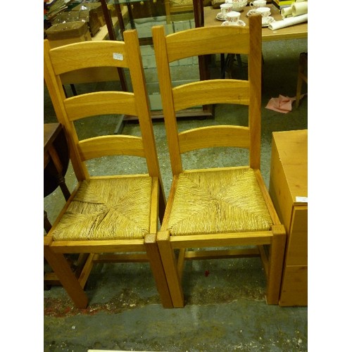 342 - A PAIR OF PINE KITCHEN CHAIRS WITH RUSH SEATS AND TALL LADDER BACKS.