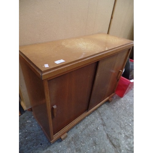 135 - SMALL MID CENTURY OAK VENEERED CABINET WITH SLIDING DOORS ON BLOCK FEET