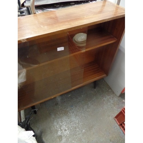 329 - RETRO GLASS DOORED CABINET WITH BLACK TAPERED LEGS. GLASS DOORS SLIDE. APPROX 90CM W.