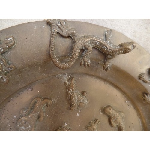 84 - AN ANTIQUE BUDDHIST OFFERING PLATE INDIAN BRASS  ON THREE LION PAW FEET, WITH APPLIED ANIMAL AND HUM... 