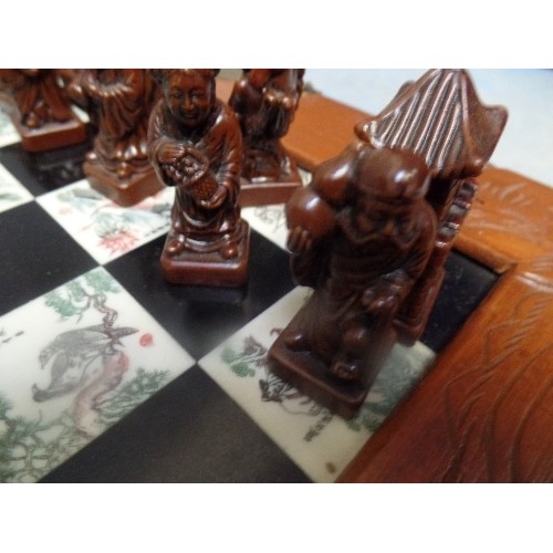 147 - A CHINESE CHESS SET WITH CARVED RESIN CHESS PIECES, THE BOARD INLAID WITH DECORATIVE PANELS, THE CAS... 