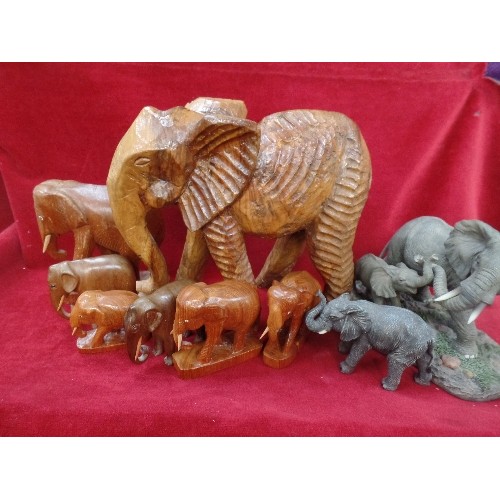 169 - A COLLECTION OF 9 ELEPHANTS, IN WOOD AND RESIN, THE LARGEST 27CM