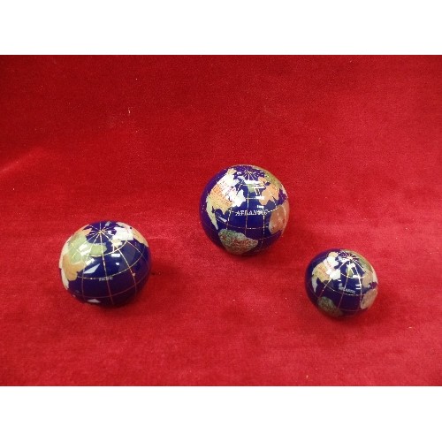 86 - THREE GRADUATED GEMSTONE GLOBES IN A FITTED BOX, THE LARGEST 7CM