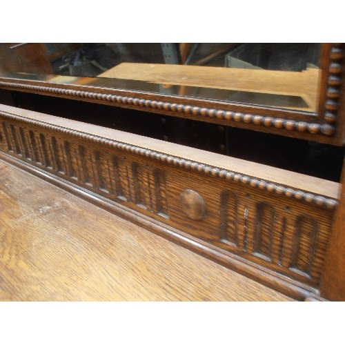 527 - 1920'S OAK DRESSING TABLE WITH TWO OVER TWO DRAWERS AND LARGE SWIVEL MIRROR WITH BEVELLED GLASS - ON... 