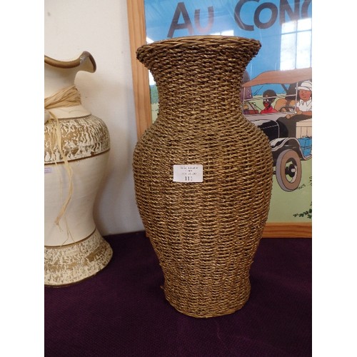 111 - 2 LARGE DECORATIVE VASES, ONE IS BASKET COVERED, THE OTHER IS CREAM/GOLD WITH RAFFIA COLLAR.