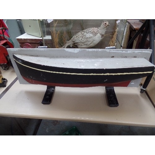 305 - A HEAVY WOODEN MODEL OF A SHIPS HULL ON CAST IRON BRACKETS