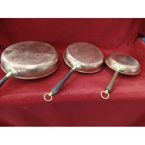 78 - 3 X GRADUATED COPPER PANS, WOODEN HANDLES WITH HANGING LOOPS. MADE IN PORTUGAL.