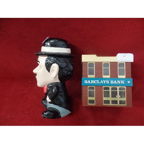 127 - 2 X VINTAGE MONEY BOXES. BARCLAYS BANK, AND CHARLIE CHAPLIN.