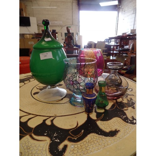 242 - COLOURFUL RETRO GLASSWARE. GREEN LIDDED VASE, PAINTED GLASS, MINIATURE VASES ETC.