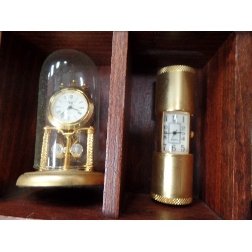 202 - 24 MINIATURE BRASS CLOCKS IN A WOODEN DISPLAY CASE