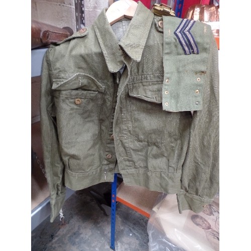 184 - A DENIM GREEN BATTLEDRESS JACKET, CORPORALS ARMBAND AND A WW2 CANVAS BELT WITH BROAD ARROW MARK 1943