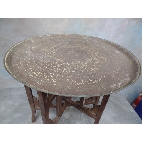 222 - A VINTAGE BENARES TABLE WITH FOLDING BASE AND PERSIAN BRASS TRAY TOP ENGRAVED WITH SCRIPT AND ANIMAL... 