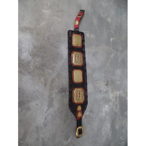 310 - A 19TH CENTURY HARNESS  STRAP WITH RED LEATHER DETAIL, 4 LARGE STUDS, TWO OF WHICH HAVE ENAMELLED IN... 