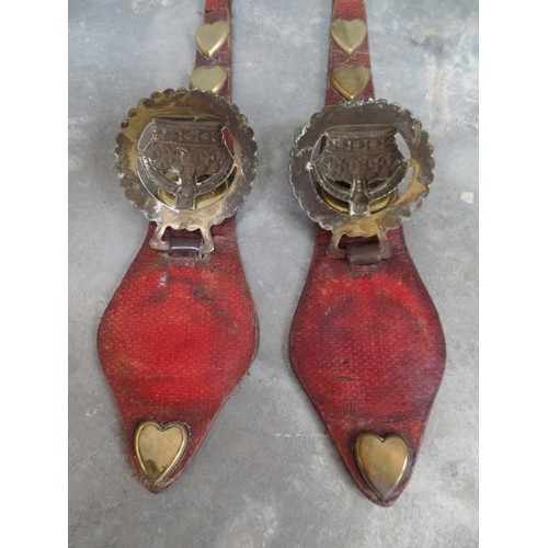 311 - A GOOD PAIR OF RED LEATHER HARNESS STRAPS WITH HEART AND OVAL STUDS AND STAMPED CROWN BRASSES (PROBA... 