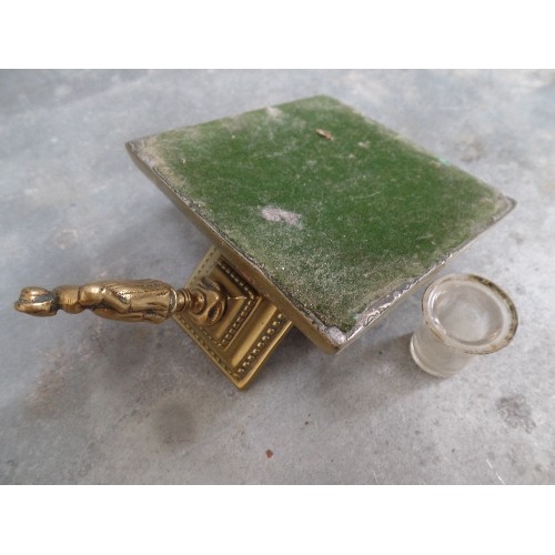 46 - VICTORIAN BRASS DESK INKWELL WITH GLASS INSERT. THE LID WITH A FINIAL OF A LADY - PROBABLY A DICKENS... 