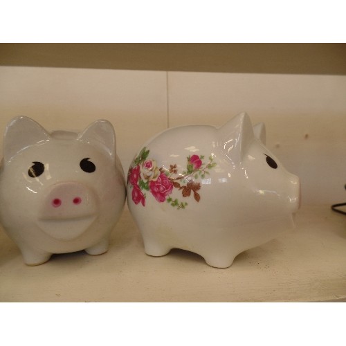 74 - 3 WHITE CERAMIC PIGGY BANKS, WITH FLORAL TRANSFERS.  ALSO A PINK PIGGY BANK.