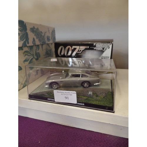 91 - ASTON MARTIN DB5 - GOLDFINGER  007 MODEL IN DISPLAY CASE AND A 007 MUG, BONE CHINA, OFFICIALLY LICEN... 