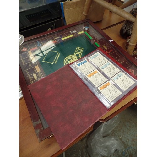 289 - LOVELY MONOPOLY SET UNDER GLASS IN WOODEN CABINET. HAS BANKERS DRAWER. REAL ESTATE PORTFOLIO CONTAIN... 