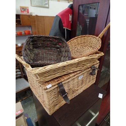 316 - 4 X WICKER BASKETS. INCLUDES A HAMPER, LONG BREAD BASKET, A SMALL DARK WICKER BOWL, AND A LONG HANDL... 