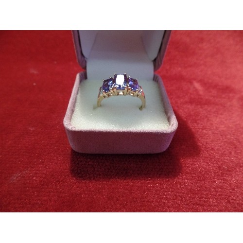 40 - A 14CT GOLD DRESS RING SET WITH THREE GRADUATED TANZANITES BETWEEN SIX DIAMONDS, 3.3 GRAMS, SIZE O/P