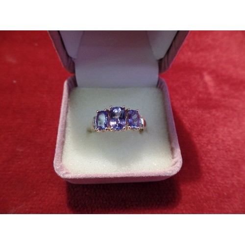 40 - A 14CT GOLD DRESS RING SET WITH THREE GRADUATED TANZANITES BETWEEN SIX DIAMONDS, 3.3 GRAMS, SIZE O/P