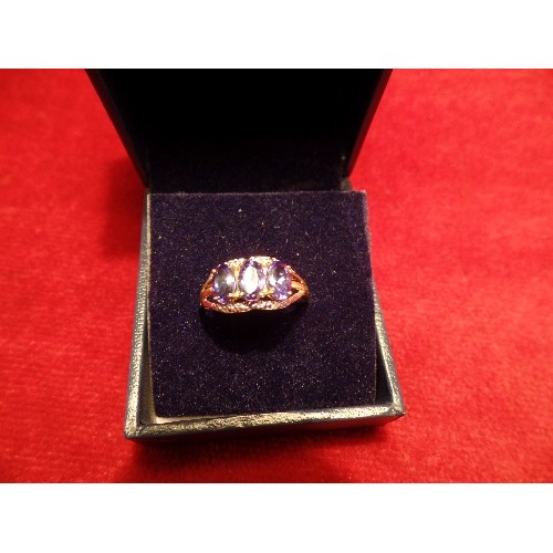 44 - A 9CT GOLD RING SET WITH 3 OVAL CUT TANZANITES SUPPORTED BY WHITE GOLD AND DIAMOND CHIP BANDS. SIZE ... 