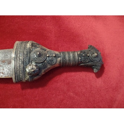 102 - A 20TH CENTURY OMANI KHANJAR DAGGER IN A SCABBARD. THE HILT AND SCABBARD HIGHLY DECORATED WITH SILVE... 