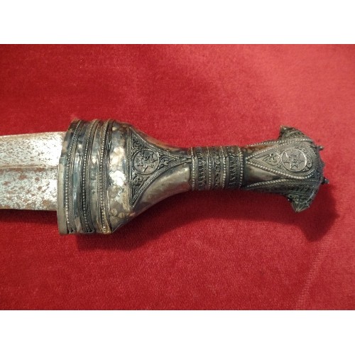 102 - A 20TH CENTURY OMANI KHANJAR DAGGER IN A SCABBARD. THE HILT AND SCABBARD HIGHLY DECORATED WITH SILVE... 