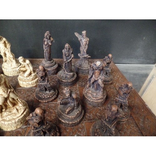 241 - LARGE CHESS SET. CARVED CHESS BOARD. RESIN WARRIOR-SKELETON PIECES.  3 PIECES HAVE BEEN REPAIRED.