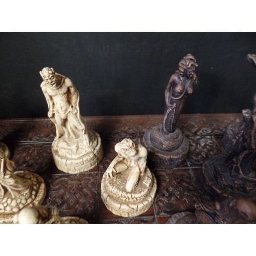 241 - LARGE CHESS SET. CARVED CHESS BOARD. RESIN WARRIOR-SKELETON PIECES.  3 PIECES HAVE BEEN REPAIRED.