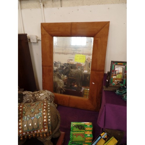 135 - LARGE BEVELLED WALL MIRROR WITH WIDE TAN SUEDETTE FRAME.