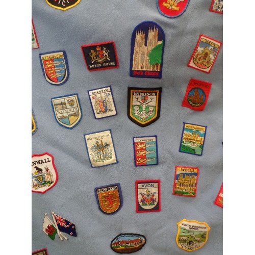 342 - FLEECE DOOR CURTAIN DECORATED WITH LARGE QUANTITY OF SEWN -ON CLOTH SOUVENIR BADGES FROM ALL OVER TH... 