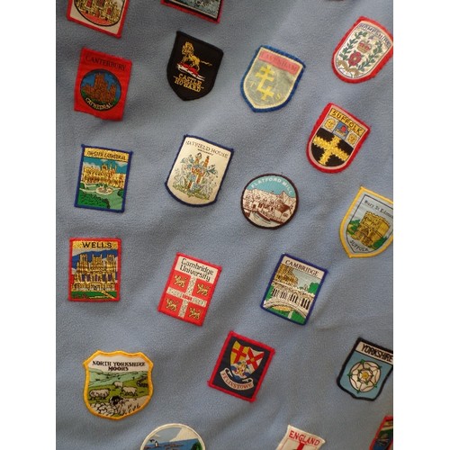 342 - FLEECE DOOR CURTAIN DECORATED WITH LARGE QUANTITY OF SEWN -ON CLOTH SOUVENIR BADGES FROM ALL OVER TH... 