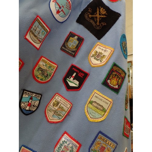 342 - FLEECE DOOR CURTAIN DECORATED WITH LARGE QUANTITY OF SEWN -ON CLOTH SOUVENIR BADGES FROM ALL OVER TH... 